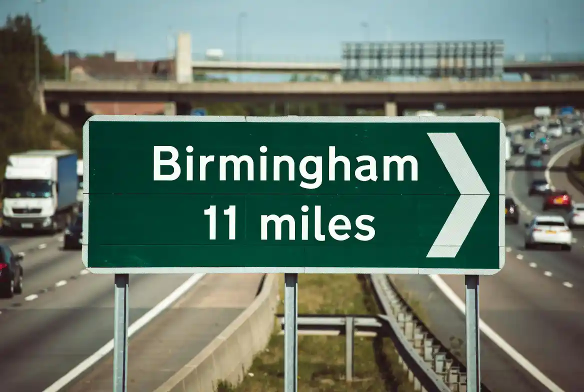 An aerial view of Birmingham's Bullring and city centre with heavy traffic on the ring road, illustrating that a big, busy second city simply has more cars, and therefore more of everything, good and bad